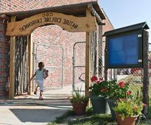 A child enters the outdoor play area at the Child Development Center